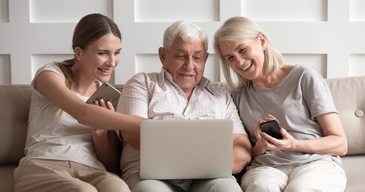 Großeltern mit Tochter vor einem Laptop - shutterstock