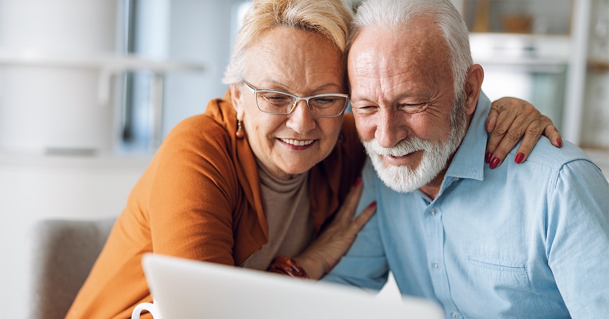 Renter Ehepaar welches glücklich auf einen Laptop schaut